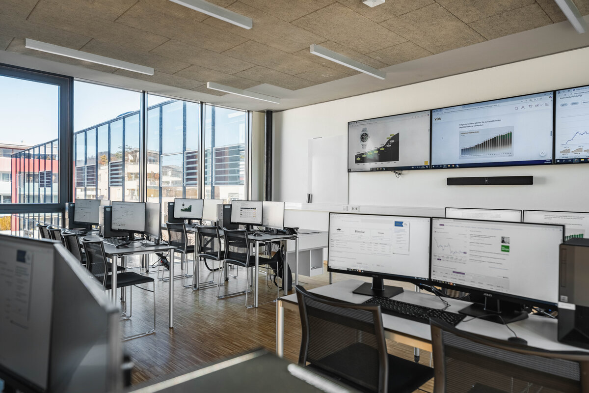Heller Seminarraum des Finance Lab der HOK mit Computerplätzen und Präsentationsmonitoren.