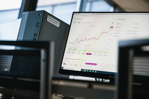 Monitor im Finance Lab der HOK zeigt Kursentwicklung und Finanzdiagramme.