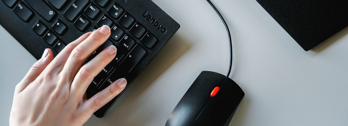 Hand tippt auf eine Computertastatur im Finance Lab der HOK.