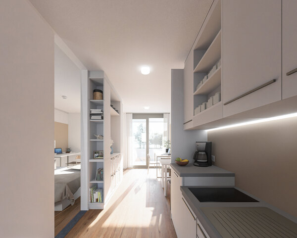 Modernes, barrierefreies Studierendenapartment der HOK, hell und lichtdurchflutet. Blick von Eingang Richtung Küche und Wohnraum. Ein Raumtrenner aus Regalen trennt den Schlaf- und Arbeitsbereich ab.   | © Architekten Adamer°Ramsauer 