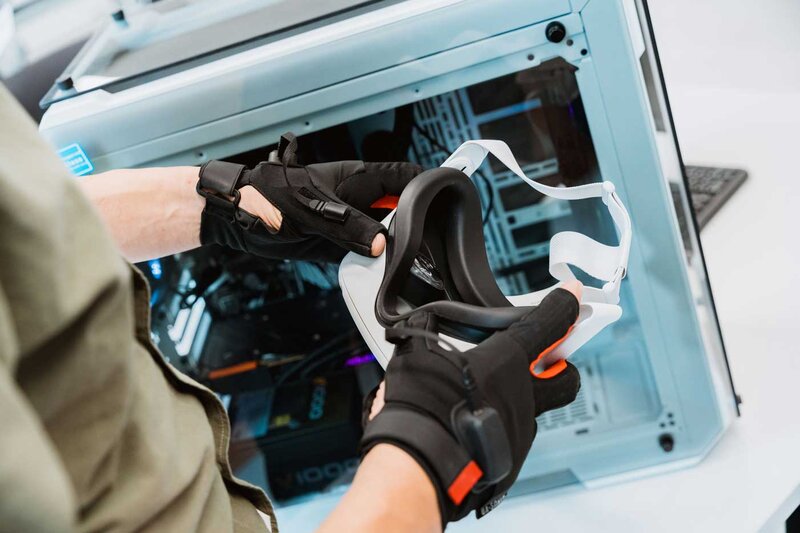 Person mit Datenhandschuhen hält VR-Brille im Web Lab der HOK.
