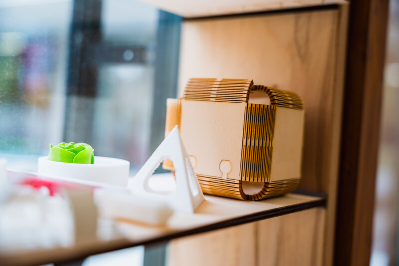 Regalausstellung im Makers Lab der HOK mit verschiedenen 3D-gedruckten und gelaserten Objekten aus Kunststoff und Holz.