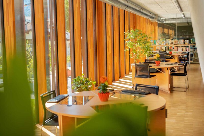 Arbeitsbereich der kubi am Campus der HOK mit Holzboden, großen Fenstern, Schreibtischen, Stühlen 