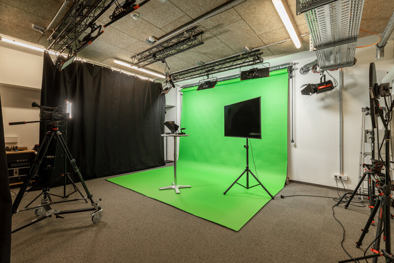 Professionelles Greenscreen-Studio im Media Lab der HOK mit Kamera, Beleuchtung und Monitor für Videoaufnahmen.