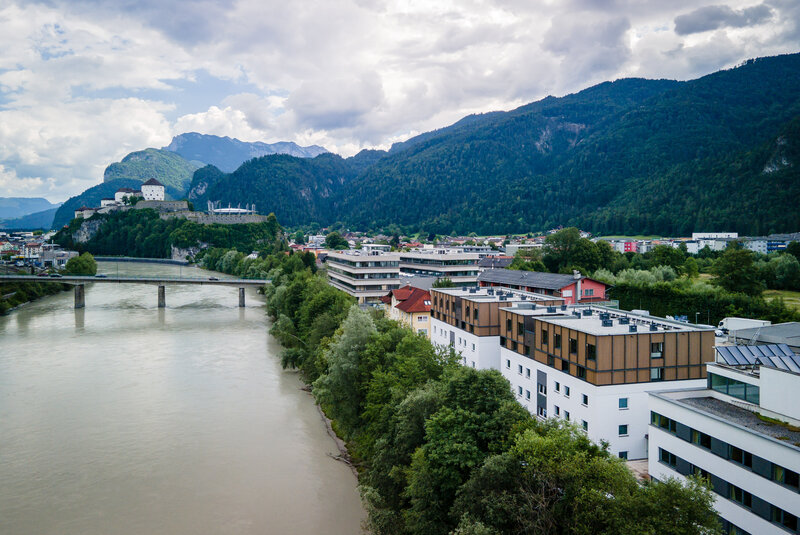Die International Student Residence aus der Drohnenansicht mit Blick auf den Inn und die Festung Kufstein im Hintergrund