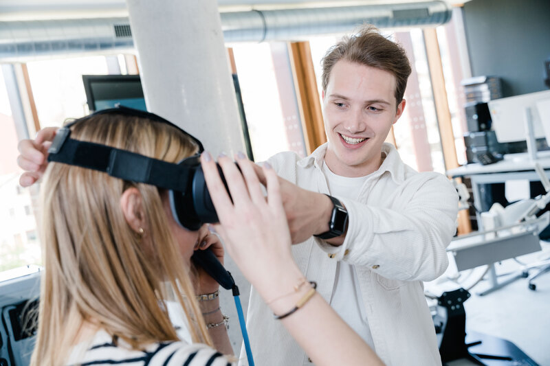 Student hilft Kommilitonin beim Aufsetzen einer Virtual-Reality-Brille im Digital Experience Lab der HOK.