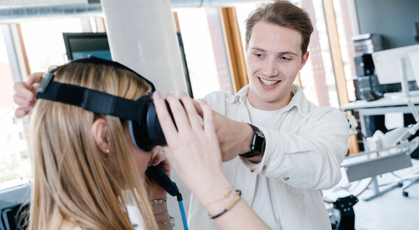 Student hilft Kommilitonin beim Aufsetzen einer Virtual-Reality-Brille im Digital Experience Lab der HOK.