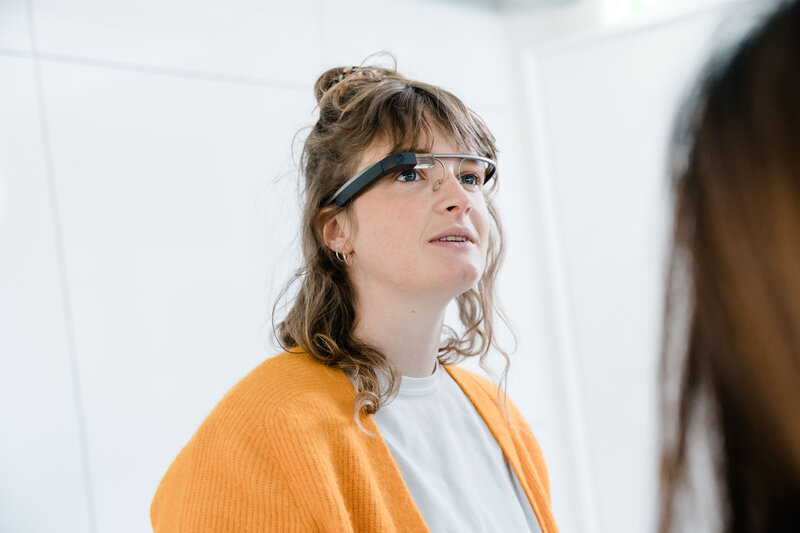 Studentin trägt eine smarte Datenbrille und beobachtet eine Demonstration im Digital Experience Lab der HOK.