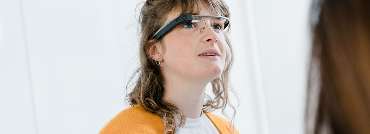 Studentin trägt eine smarte Datenbrille und beobachtet eine Demonstration im Digital Experience Lab der HOK.