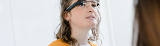 Studentin trägt eine smarte Datenbrille und beobachtet eine Demonstration im Digital Experience Lab der HOK.