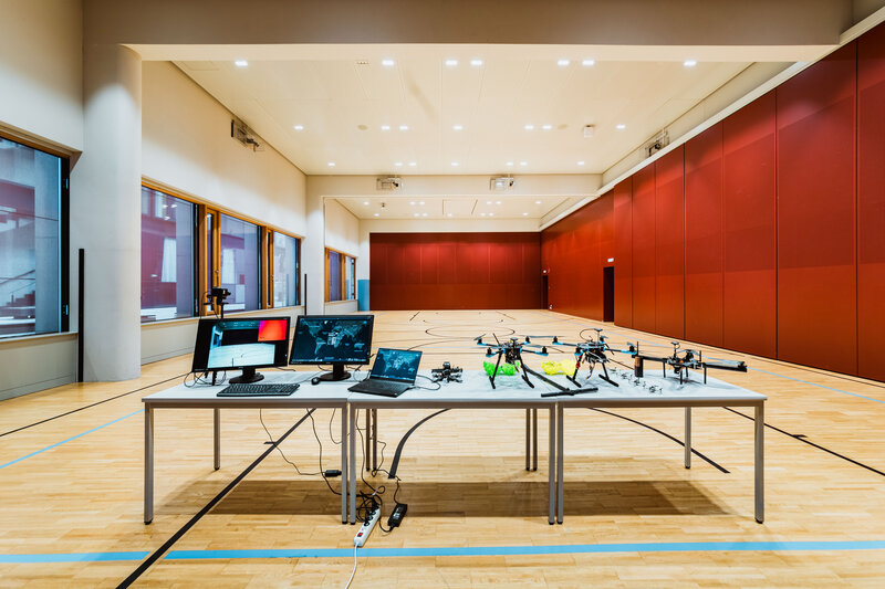 Versuchsaufbau im Drone Lab der HOK mit Drohnen, Monitoren und Steuerungscomputern im Drohnenlabor.