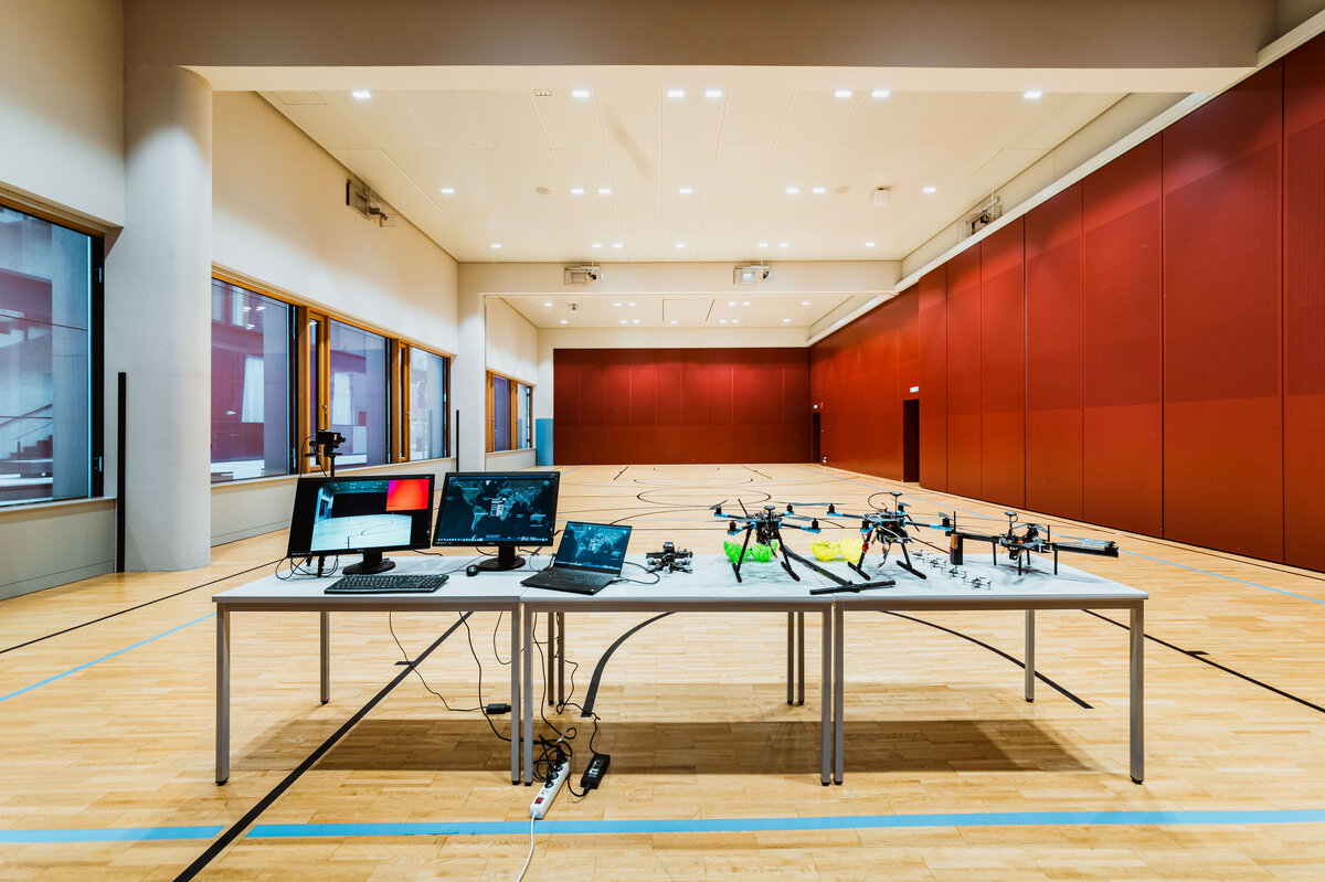 Versuchsaufbau im Drone Lab der HOK mit Drohnen, Monitoren und Steuerungscomputern im Drohnenlabor.