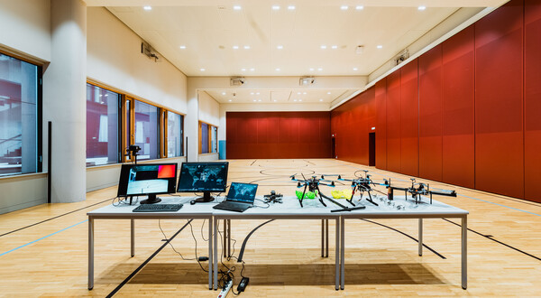 Versuchsaufbau im Drone Lab der HOK mit Drohnen, Monitoren und Steuerungscomputern im Drohnenlabor.