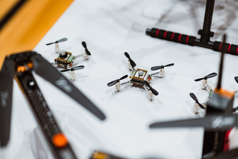  Nahaufnahme eines Drohnenlabors mit mehreren kleinen Quadrocopter-Drohnen auf einer weißen Oberfläche.