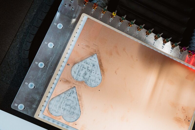 Schneidmaschine im Makers Lab der HOK graviert Herzformen präzise in eine Kupferplatte.
