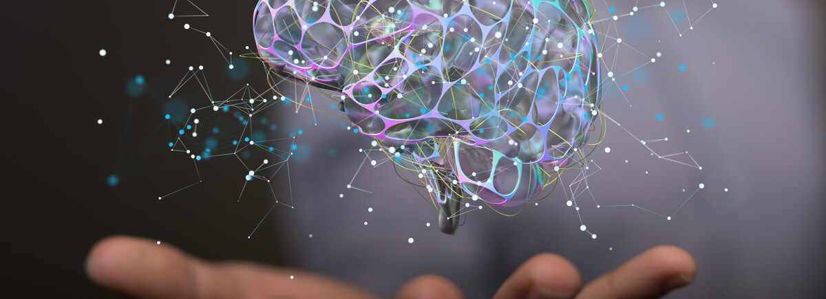 Digitale Darstellung eines leuchtenden Gehirns, das über einer ausgestreckten Hand schwebt – Symbol für künstliche Intelligenz, Wissen und Innovation.
