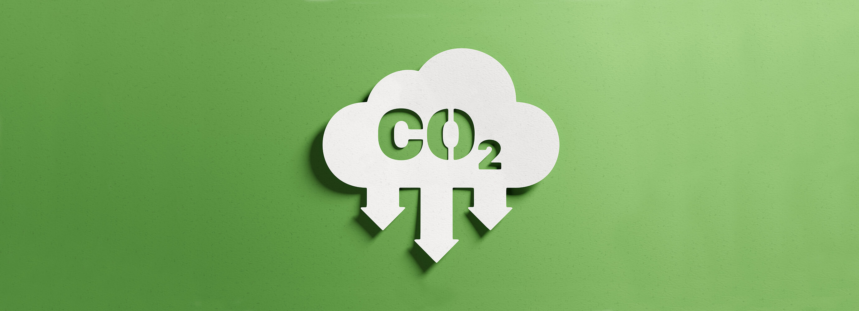 Weiße Wolke mit CO₂-Symbol und nach unten gerichteten Pfeilen auf grünem Hintergrund, sinnbildlich für Emissionsanalyse und Reduktion von Treibhausgasen. | © AdobeStock.NicoElNino