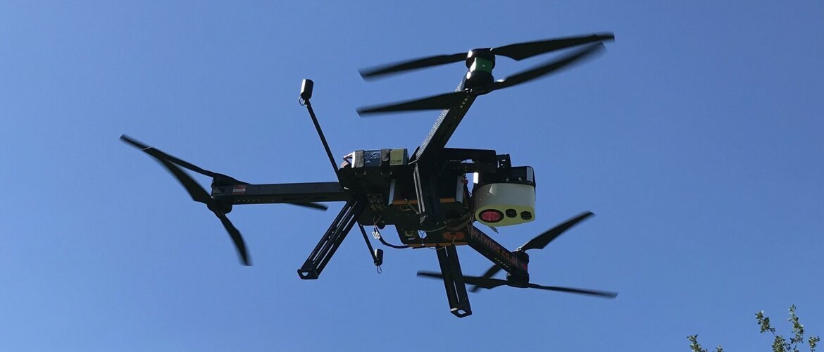 Multikopter-Drohne mit Kamera und Sensoren im Flug vor blauem Himmel. | © Twins