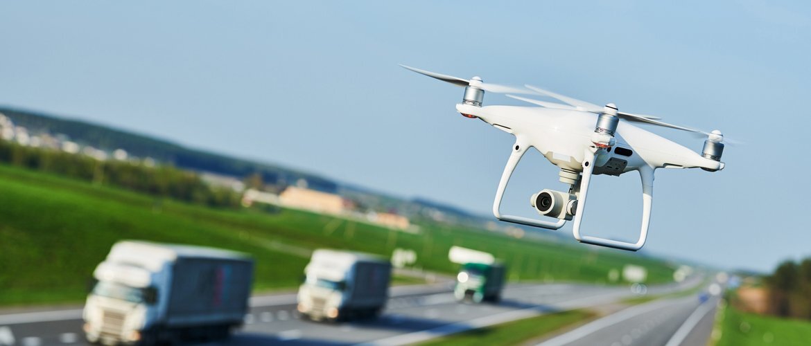 Weiße Drohne fliegt über einer Autobahn mit vorbeifahrenden Fahrzeugen – Symbol für Luftbildaufnahmen, Verkehrsanalyse und moderne Sensortechnologie. | © AdobeStock.Kadmy