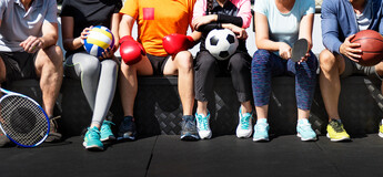 Mehrere Personen mit unterschiedlichen Sportutensilien sitzen nebeneinander – Sinnbild für Vielfalt, Gemeinschaft und die verbindende Kraft des Sports.