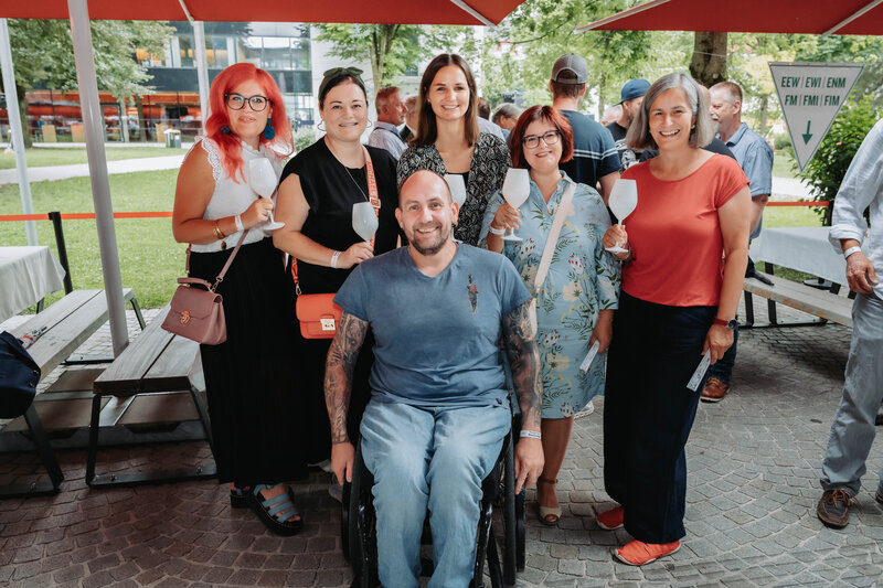 Mitarbeitende der HOK posieren im Außenbereich des HomeComing-Events für ein Foto. 