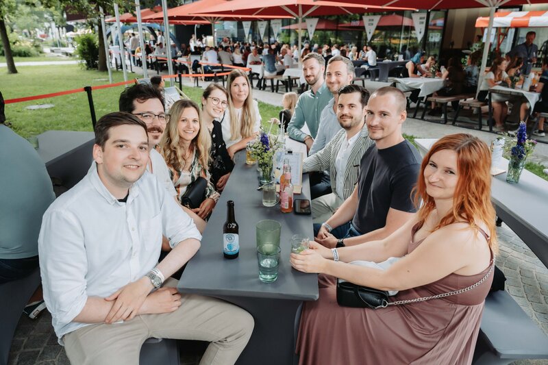 Homecoming-Besucher:innen genießen die Atmosphäre und posieren für Schnappschüsse an einem Tisch vor der HOK.