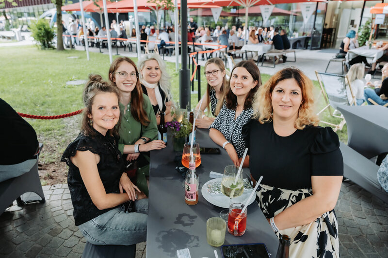 Lachende Gäste am gedeckten Tisch beim Homecoming 2025.