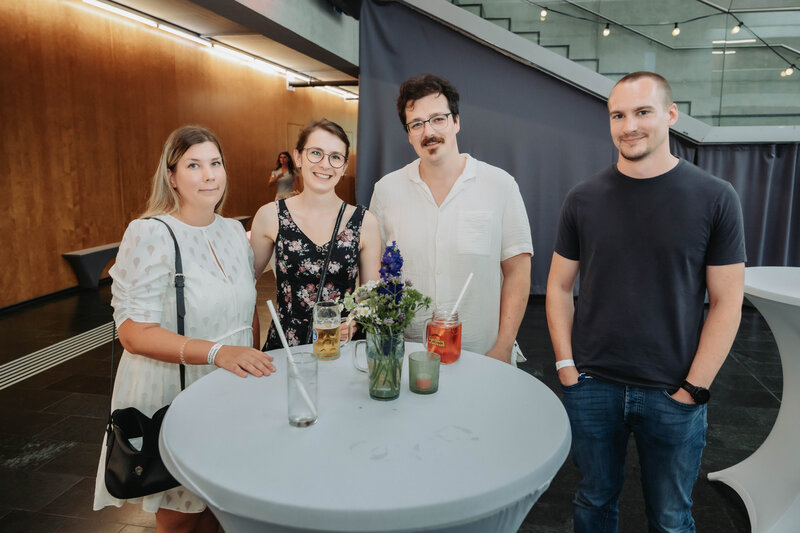 HomeComing-Gäste stellen sich lächelnd für das Foto auf.
