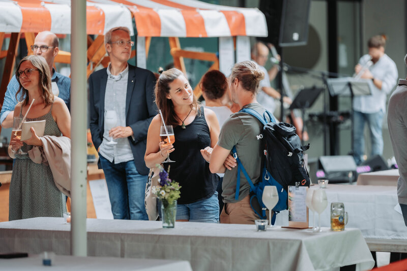 Zwei Besucher:innen des HomeComings im Gespräch. 