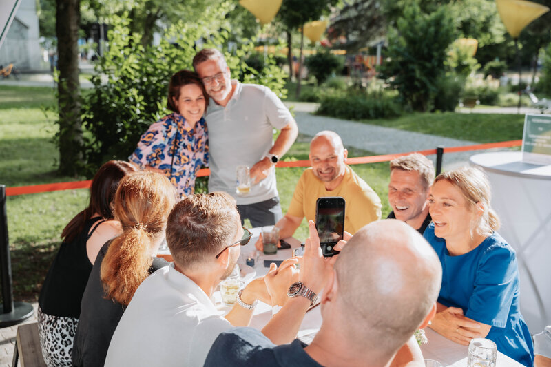 Eine Gruppe Homecoming-Gäste versammelt sich lächelnd für ein Erinnerungsfoto.