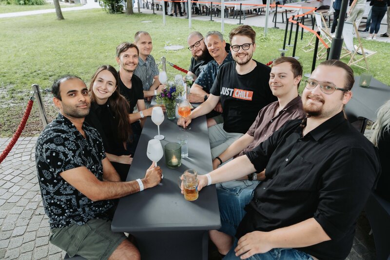 Gäst:innen lachen ungezwungen, während sie für einen Schnappschuss posieren.