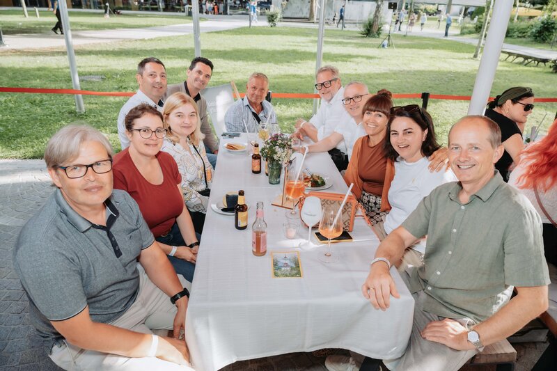 Eine Gruppe lacht gemeinsam in die Kamera.