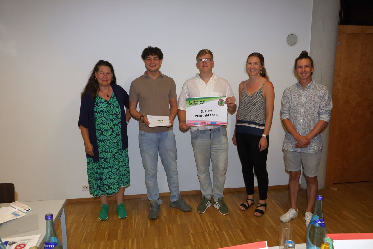 Das Team Teil-Mal zusammen mit Lehrenden bei Preisverleihung, mittig mit Urkunde und Preisgeld.