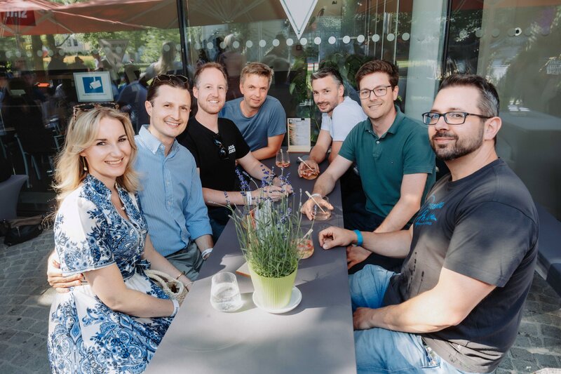 Alumni tauschen sich beim HomeComing 2026 der Kufsteiner Hochschule an einem Tisch aus.