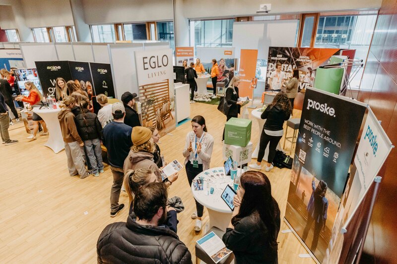 Hier sieht man eine Übersicht der Meet & Match 2024 an der HOK mit einer Vielzahl von Messeständen und Personen.