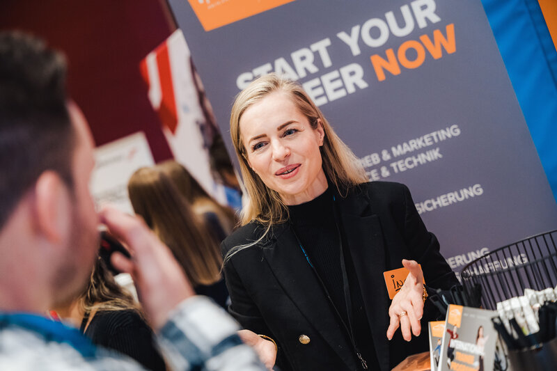 Eine Person informiert sich an einem Meet & Match Messestand.