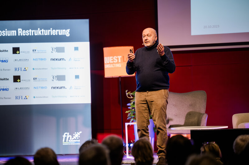 Vortragender Prof. Dr. Christoph Paulus auf der Bühne an der HOK beim 12. Internationalen Symposium Restrukturierung an der HOK