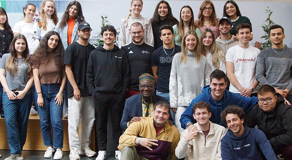 Gruppe Studierender der HOK mit Gastlektor Bella Bello Bitugu in der Aula der Hochschule