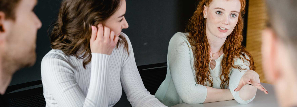 Studierende der HOK diskutieren angeregt in einer Projektarbeit und tauschen Ideen aus.