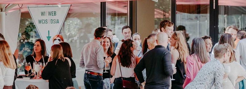 Alumni und Mitarbeiter:innen der HOK beim Home Coming 2024 im lebhaften Austausch auf der Campus-Terrasse.