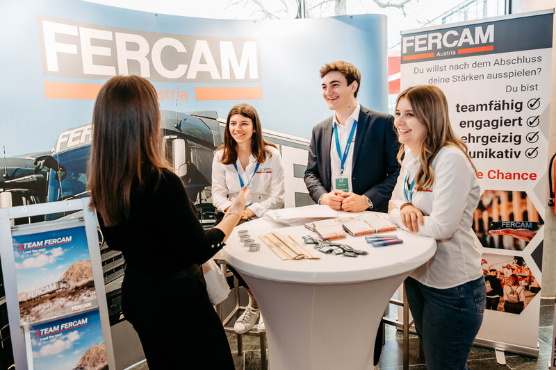 Fercam-Stand auf der Meet & Match 2024 der HOK mit Besucher:innen und Standbetreuer:innen