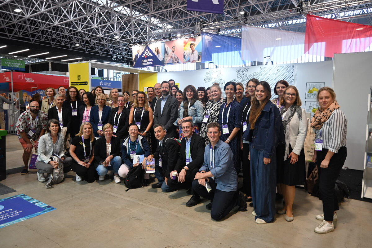 Gruppenfoto der Teilnehmenden vor Messestand