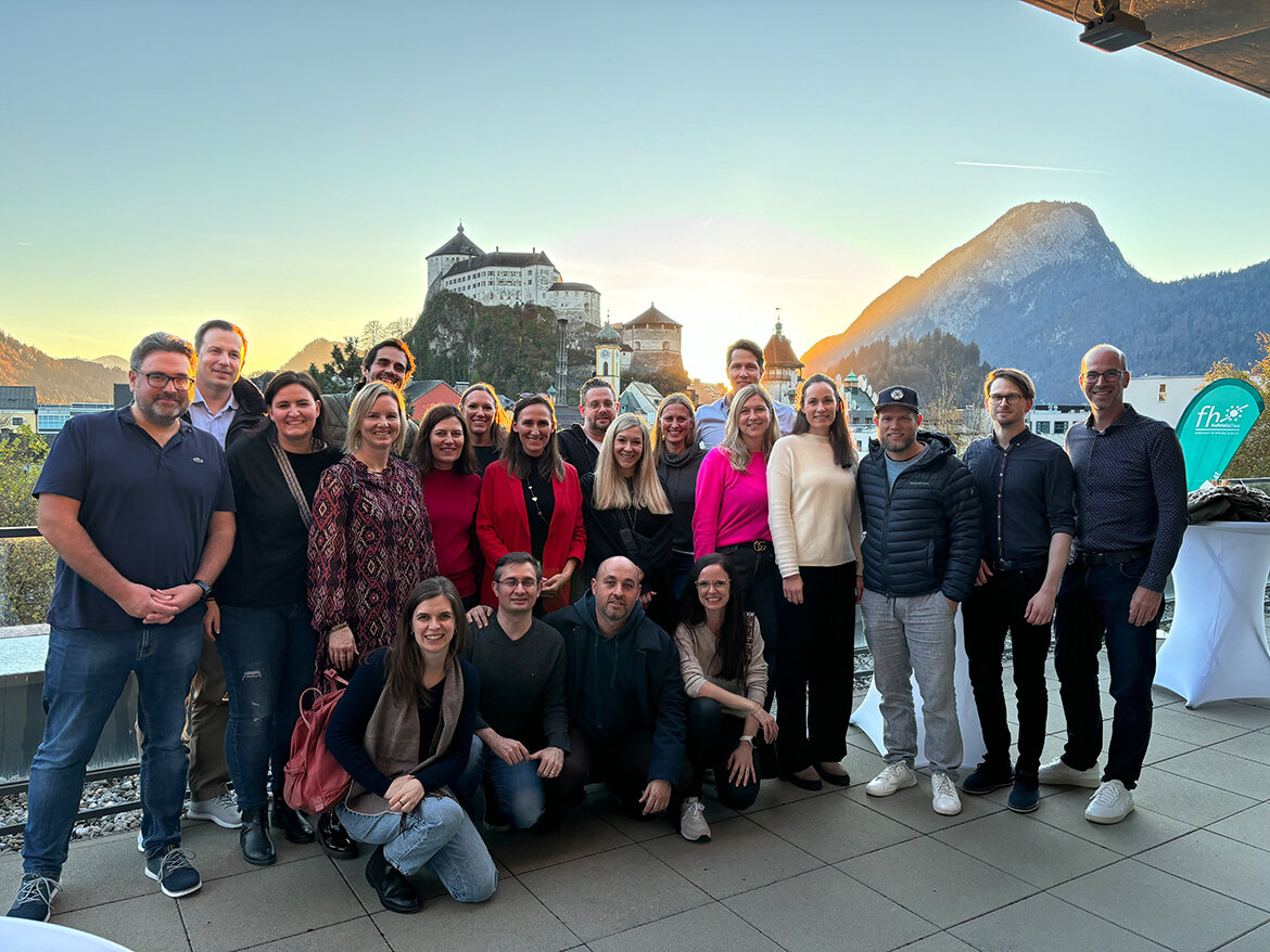 Alumnis zum Gruppenfoto auf der Dachterasse mit der Festung im Hintergrund