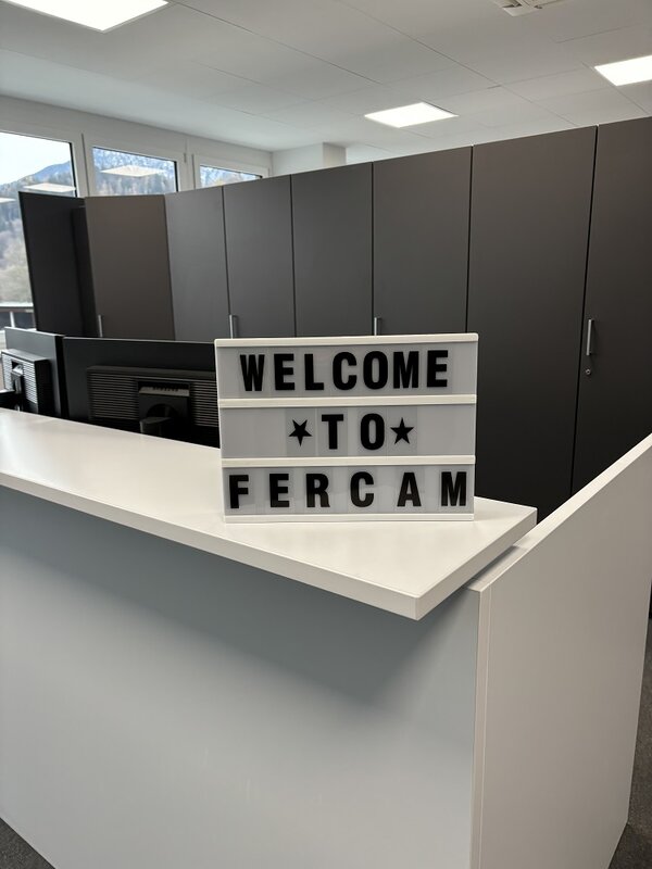 Ein Schild steht auf einem Tresen, audem dem steht Welcome to Fercam.