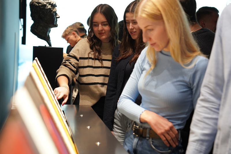 Studierende stehen an Ausstellungstisch