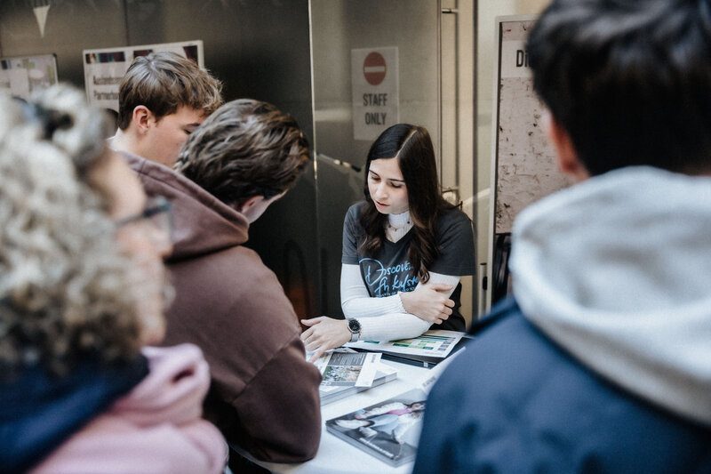 Gruppe von Gästen lässt sich an Infostand der HOK beraten