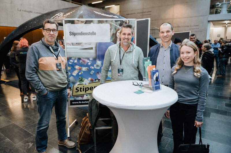 Personen posieren am Stand der Stipendienstelle am Tag der offenen Tür an der HOK. 