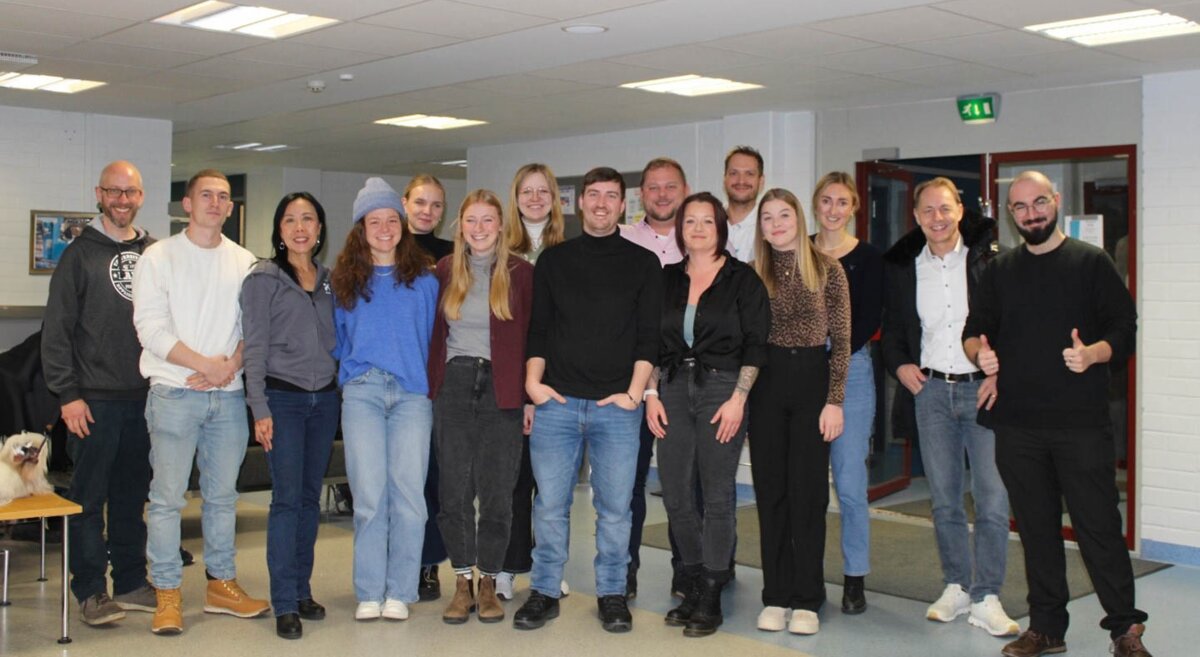 Gruppenfoto der Studierenden der HOK, aufgenommen in einem Innenraum in Kajaani, Finnland. Die Teilnehmenden des "Blended Intensive Program" posieren lächelnd 