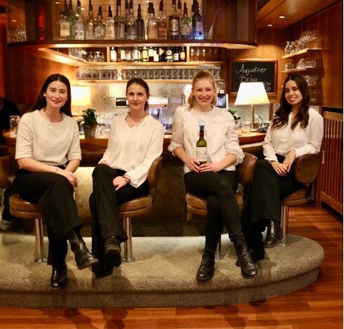 SKVM Team sitzen auf Barhockern an der Bar