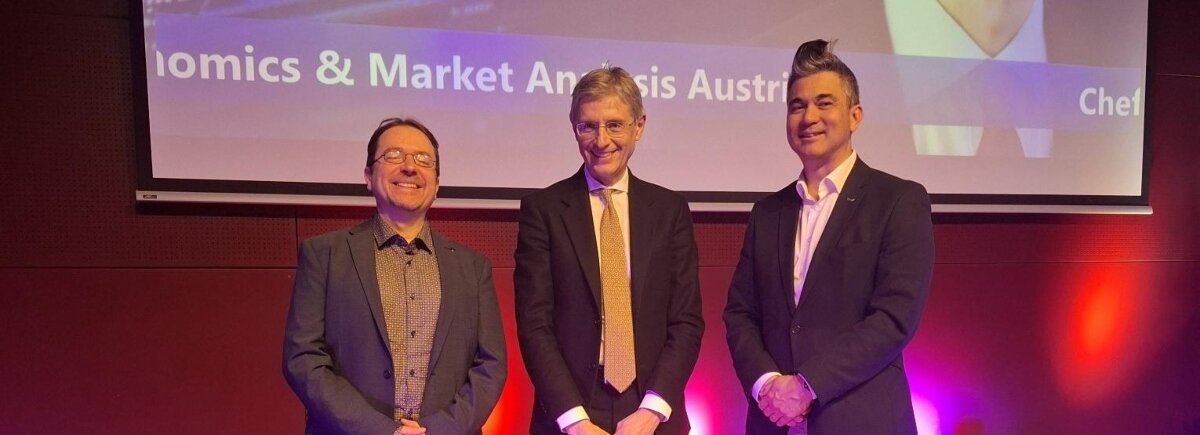 Gruppenfoto auf einer Bühne: Studiengangsleiter Prof. (FH) PD Dr. Christoph Hauser, Mag. Stefan Bruckbauer und der Präsident des Lions Club Kufstein, Volker Steindl, stehen nebeneinander. Der Hintergrund ist in warmen Farbtönen beleuchtet.